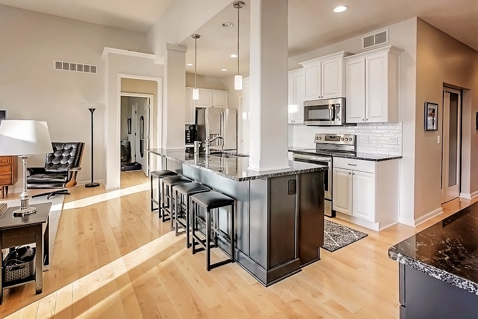 Overview of kitchen painted white cabinets in sherwin williams zurich white and island in sherwin williams greenblack.
