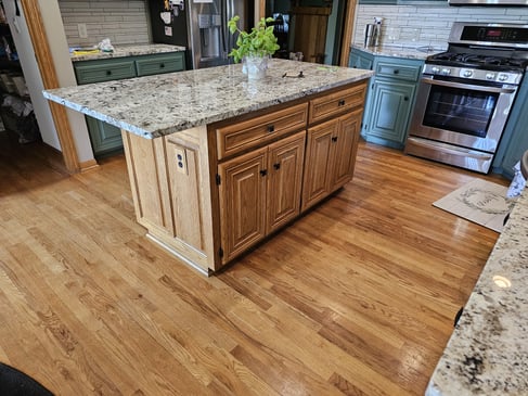 Golden oak kitchen cabinet island with a basic refinish, clear coat applied to the cabinets.