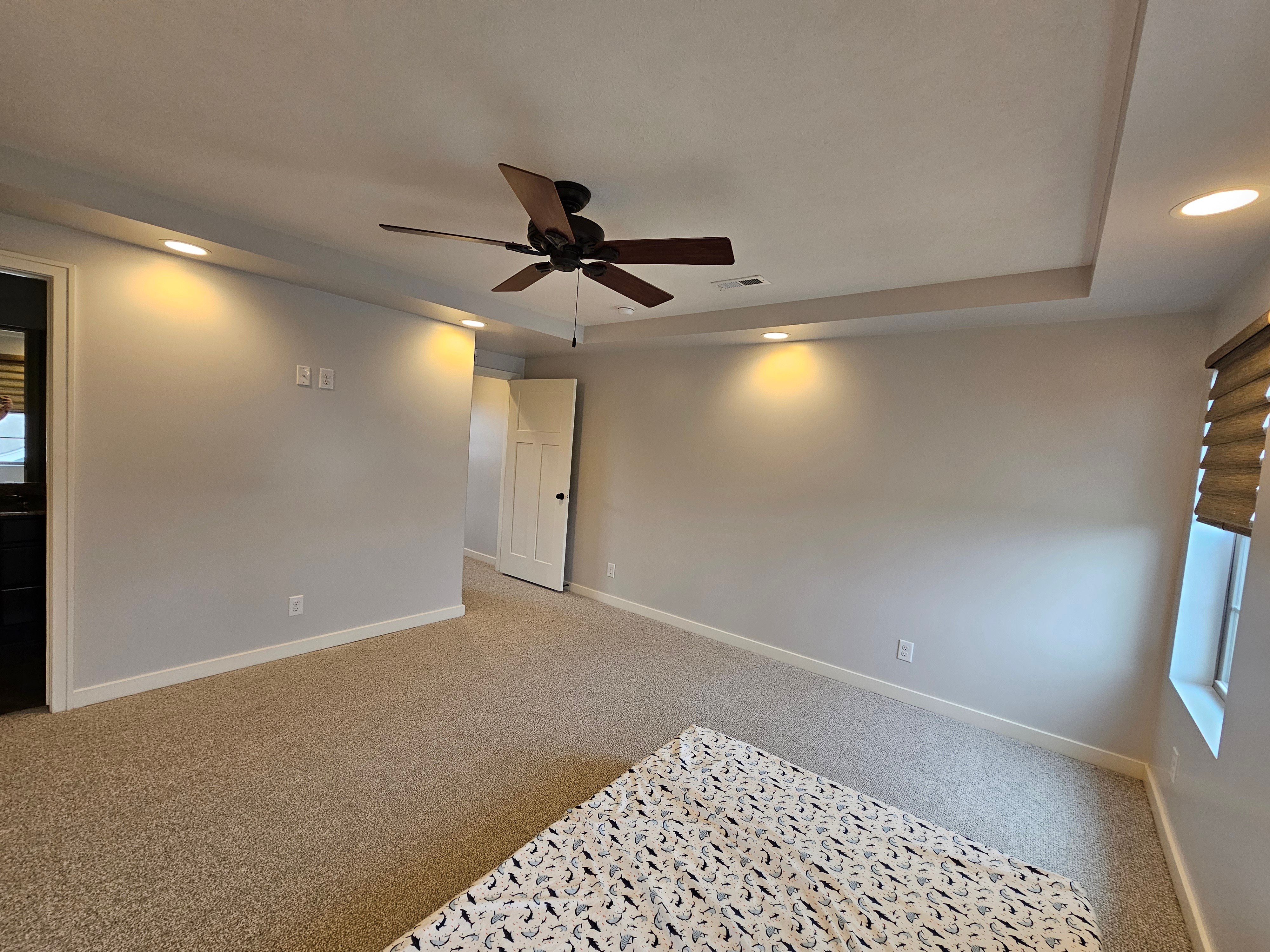 Interior bedroom freshly painted a light grey with white trim and white ceilings.