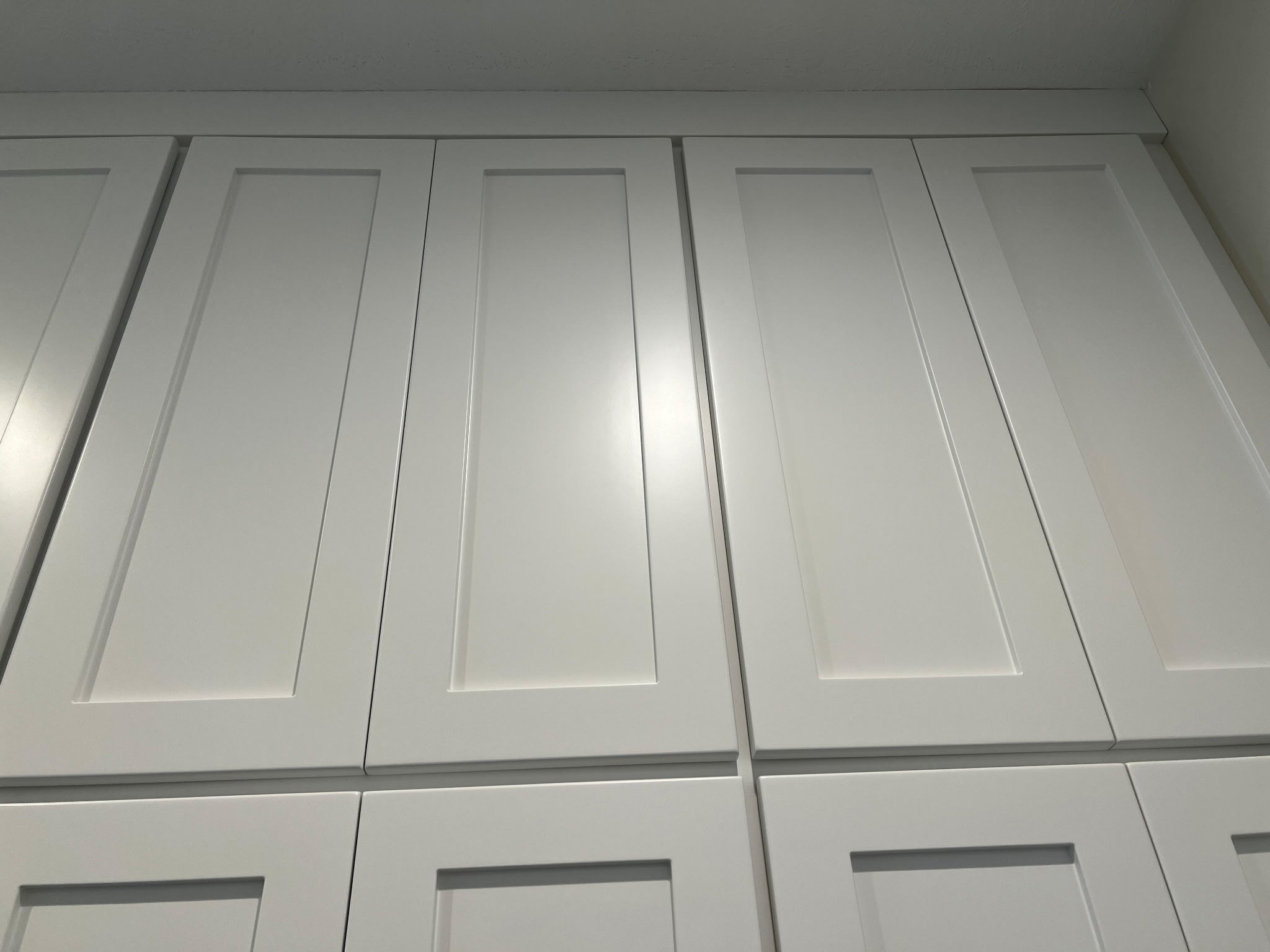 Large upper cabinets painted a light grey color by Brush & Roll Painting in Omaha, NE.