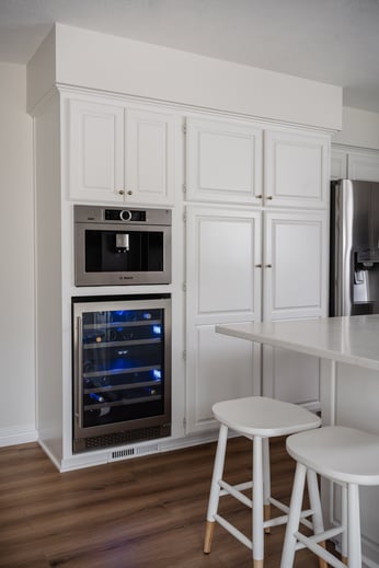 White painted kitchen cabinets with oven built in.