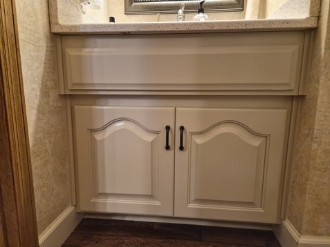 Bathroom vanity painted a creamy white color with black bronze handles.
