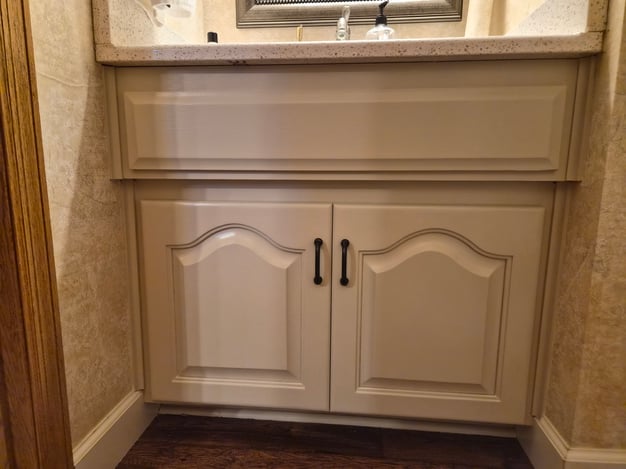 Bathroom cabinet vanity with 2 doors and a dark bronze handle inside a guest bathroom in omaha, NE.