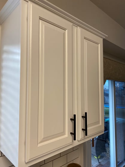 Cabinet door painted white with black handles in a kitchen in Omaha, NE.