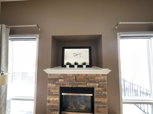 Fireplace with empty hole above the mantel for decorations and walls painted a light brown.