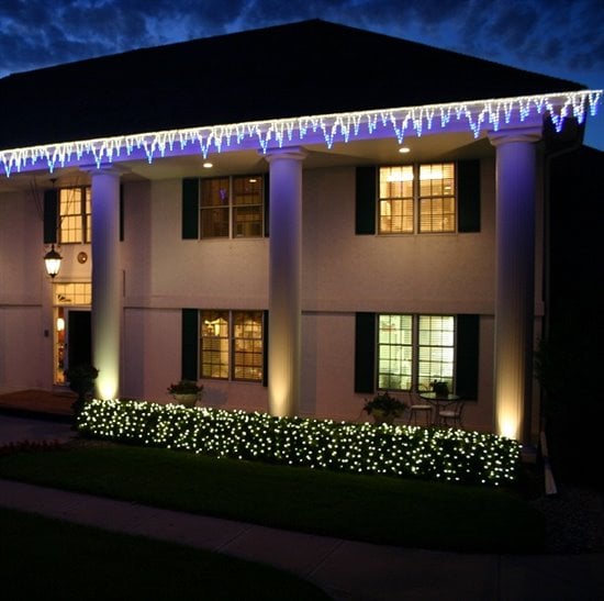 Lights on roofline and bushes outside of a house in Omaha, NE for christmas.