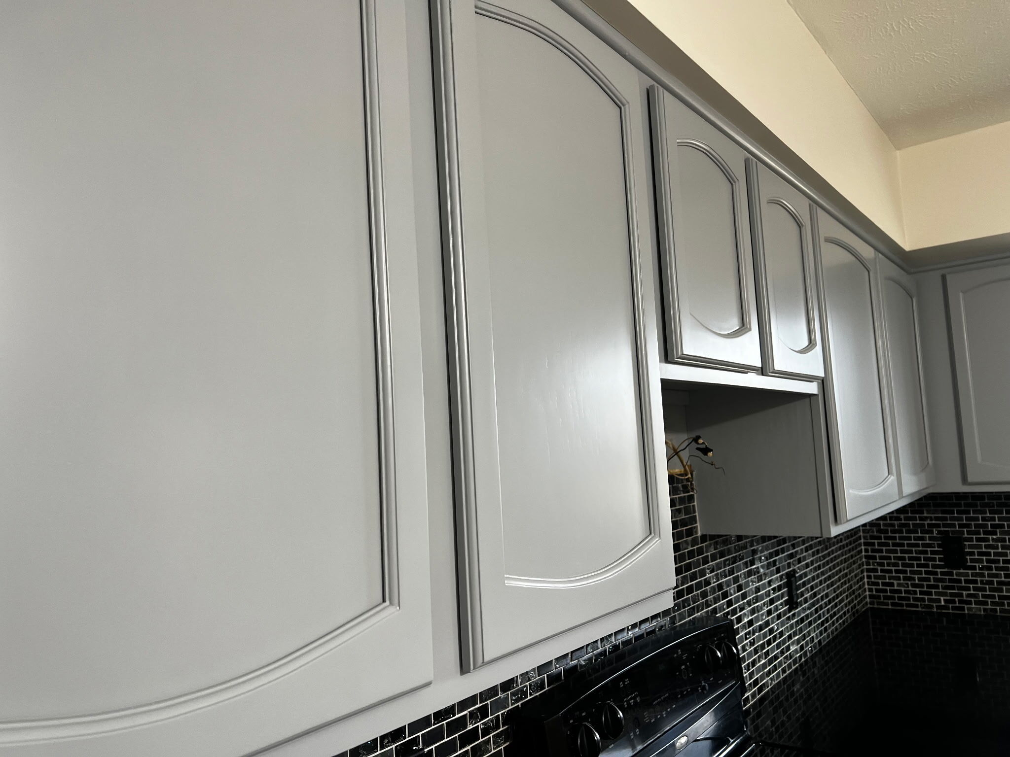 Upper cabinet doors in a kitchen painted a light grey color in Omaha, Nebraska.