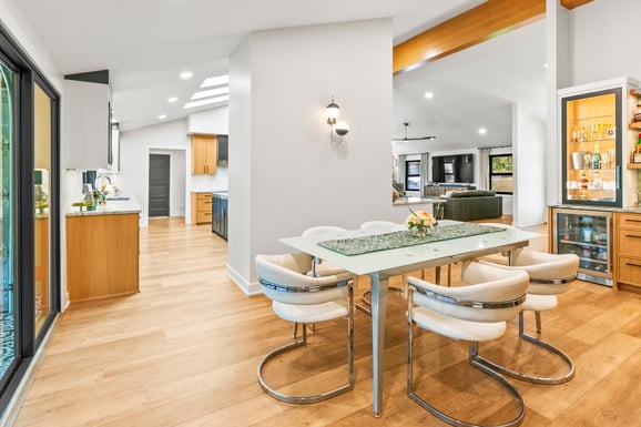 Dining room area in a open concept house with flat grey walls and warm oak woodwork.