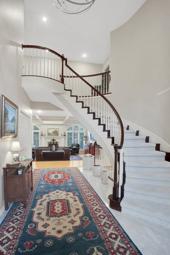 View from bottom of stairs of railing and banister painted white and stained brown in a Omaha home.