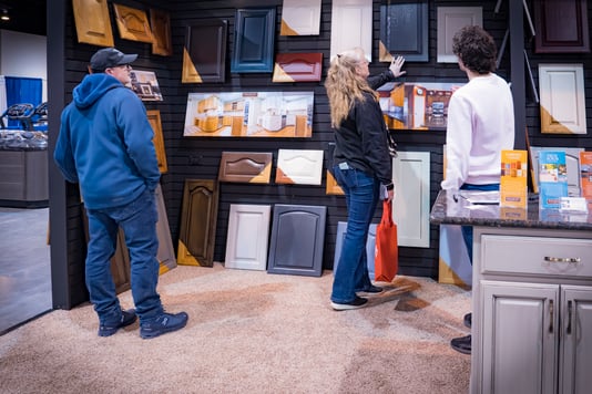 Homeowners looking at cabinet doors in Brush & Roll painting home show booth at the CHI health center.