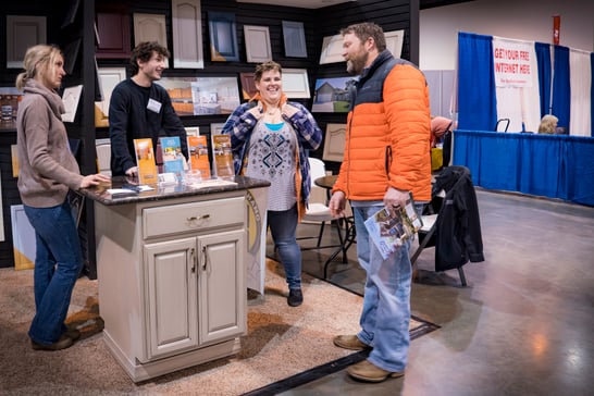 Painters talking with a homeowner at a booth at the CHI health center omaha home show.