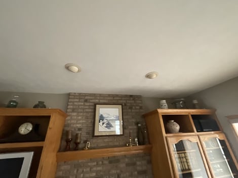 Ceiling in living room of home with yellow stained recessed lights.