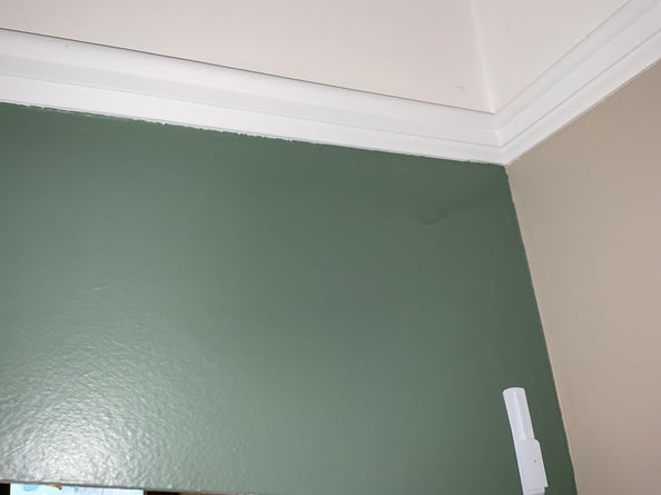 White paint from trim smudged on to emerald green painted wall.