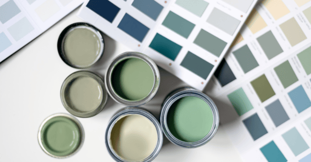 Green paint cans and samples laid out on a table.