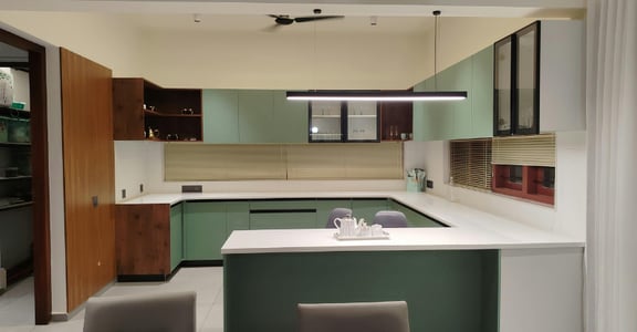 Green and black metal cabinets freshly painted in a kitchen with white countertops.