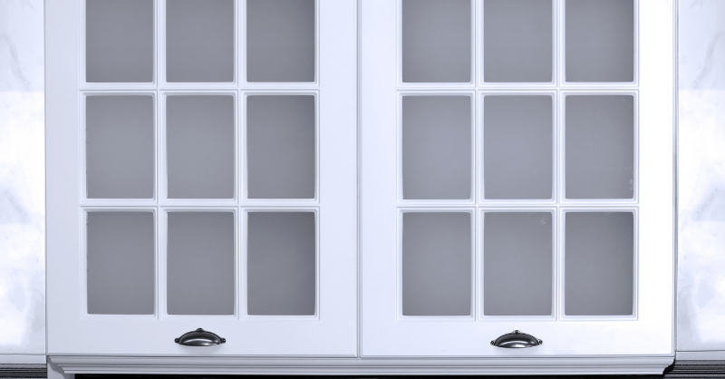 White kitchen cabinets with glass panels.