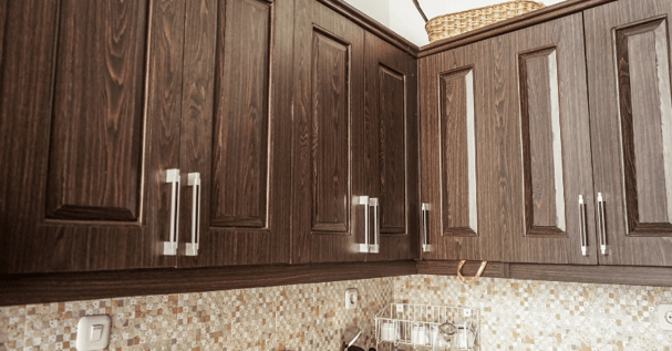 Dark brown painted laminate upper kitchen cabinets.