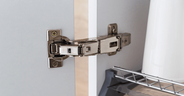 Hidden cabinet hinge on white cabinet door and cabinet box.