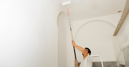 Man painting ceiling and walls white.