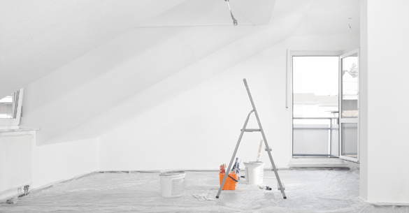 Empty bedroom after being painted white with a bright light coming from the sun through the window.