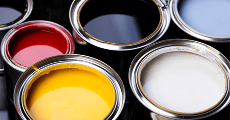 paint cans with lids open exposing a black, red, yellow, and white
