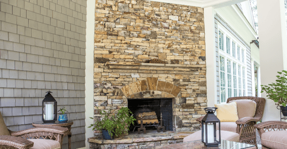 Outdoor space with fireplace and stone blocks around it and furniture.