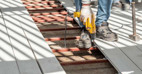 Person drilling composite deck boards on to deck outside of home in Omaha.