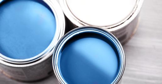 Top view of paint cans with lids off with two blue paint cans and one white.
