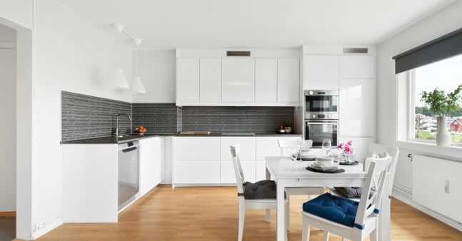 White metal cabinets in a kitchen with stainless steel appliances.