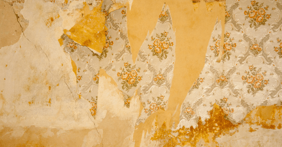 Wallpaper peeling off yellow wall.