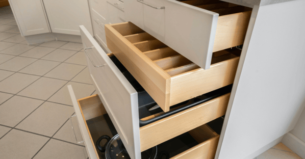 Soft close drawers in a kitchen with white cabinets.