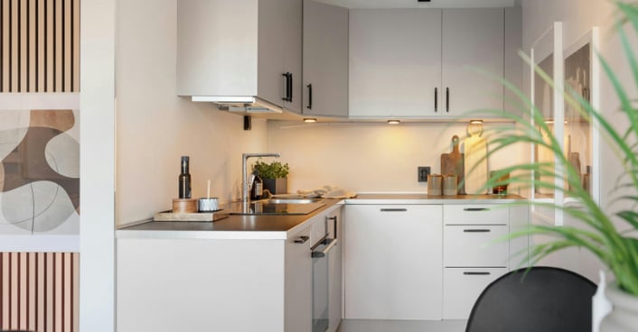 Small kitchen with beige painted cabinets.