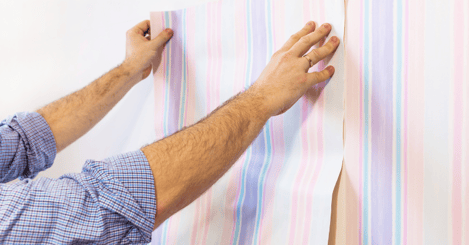 Person installing interior wallpaper sticker.