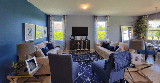 Living room with blue accent wall and blue decor and furniture and grey painted wall.
