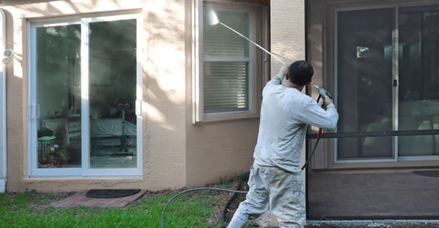 Home owner in Omaha power washing their home.