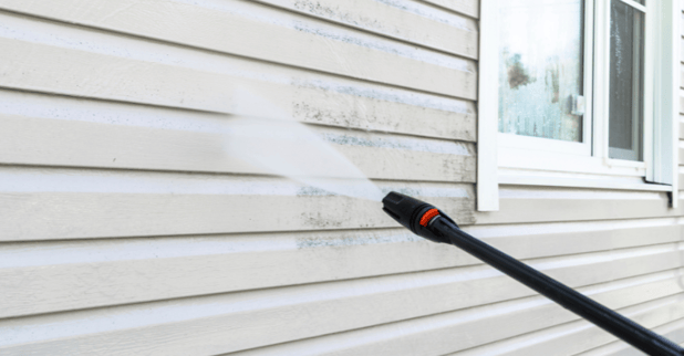 Vinyl siding being power washed to clean it in Omaha, NE.
