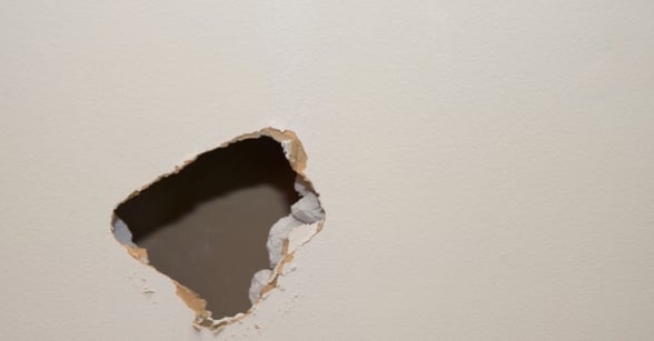 Hole in wall painted white that needs patched before painting.