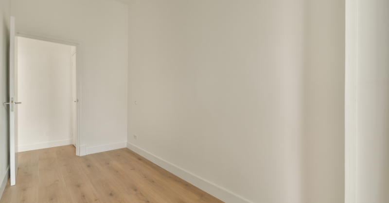 Interior room in a lake house with a wood floor and white walls and trim that expands and contracts.