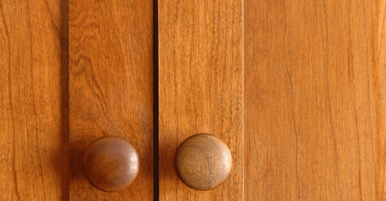 Golden oak cabinet doors and knobs.