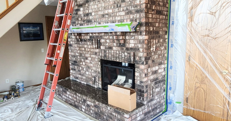 Brick mason fireplace inside a home before being painted or limewashed white.