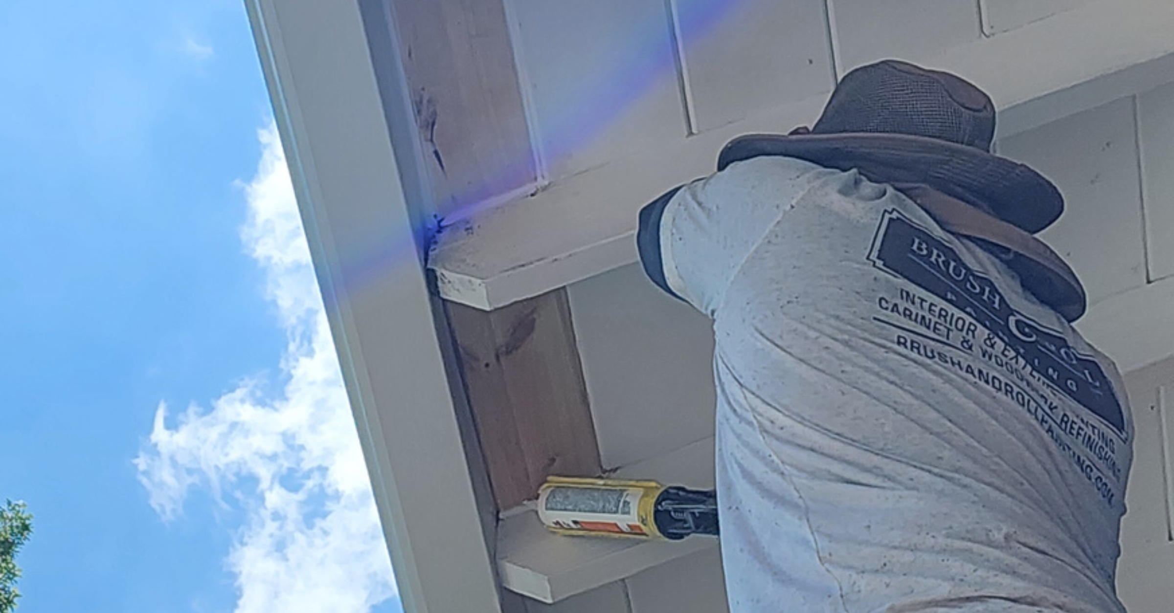 Exterior house painter caulking gap in wood covering outside of a home in Elkhorn, NE.