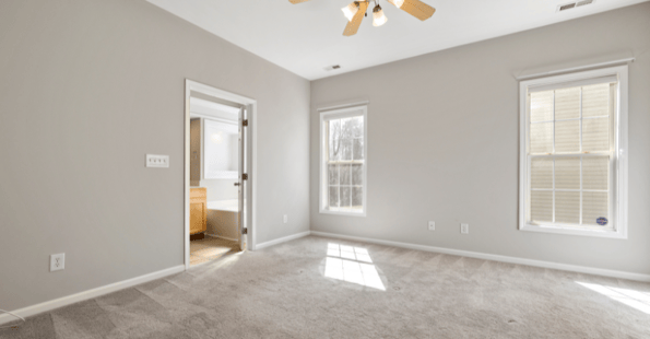 Interior bedroom painted light grey with white trim and windows open to help paint dry faster.