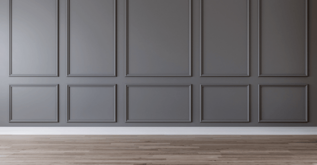 Room with a wall with trim accents painted a dark black with white trim and wood floors.