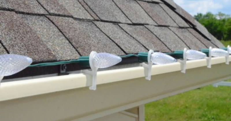 C9 bulbs and clips installed on the roofline of a house for Christmas lights.