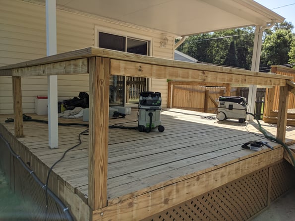 Sanders with vacuum attachment on a wood deck to remove old stain.