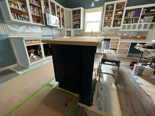 Paper covering floor and countertop in a kitchen when cabinets are being painted.