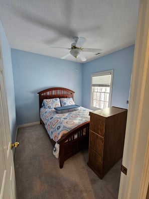 Bedroom painted a soft baby blue color with white trim and white painted ceiling.