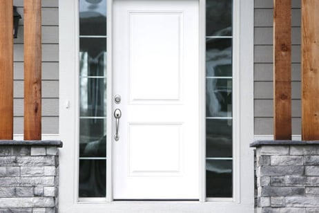 White front door with a light grey exterior of home.