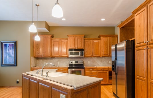 Golden oak kitchen cabinets and floors before painting cabinets.