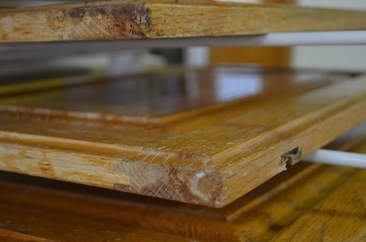 Golden oak cabinet doors with damaged corners.